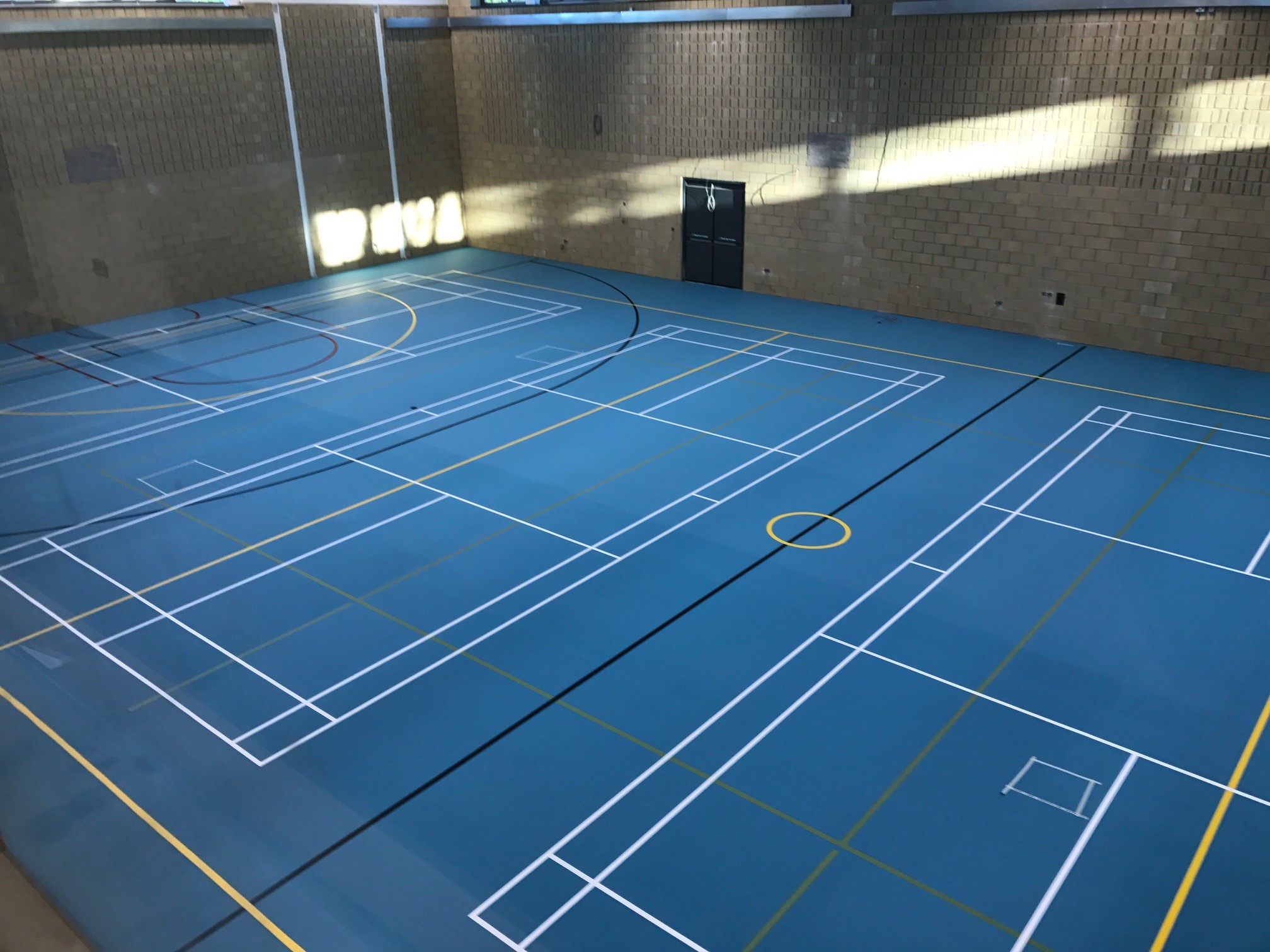 School sports hall blue Pulastic floor installation and court markings by Sports Surfaces UK