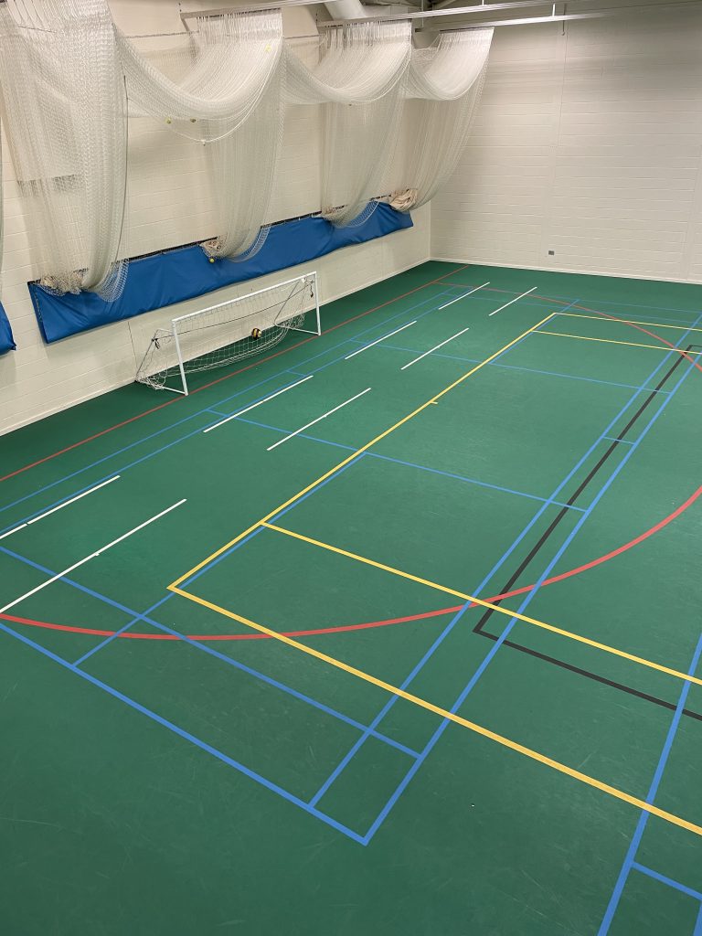 Freshly refurbished netball court with green Uni-Turf surface installed by expert sports flooring contractors