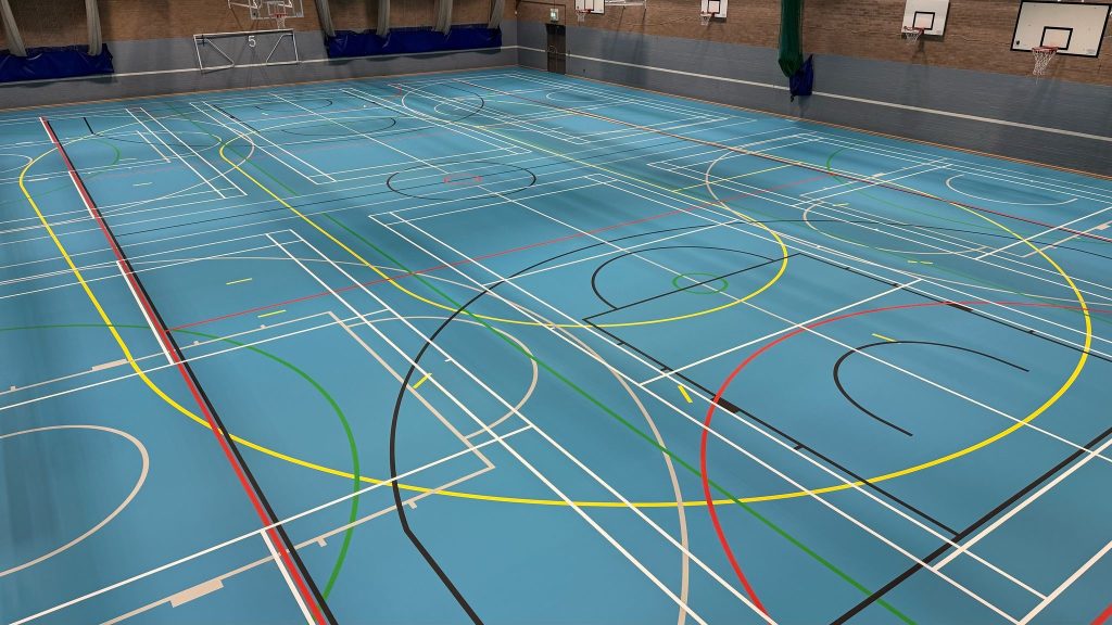 Pulastic multiuse sports hall with custom yellow roller derby track marking